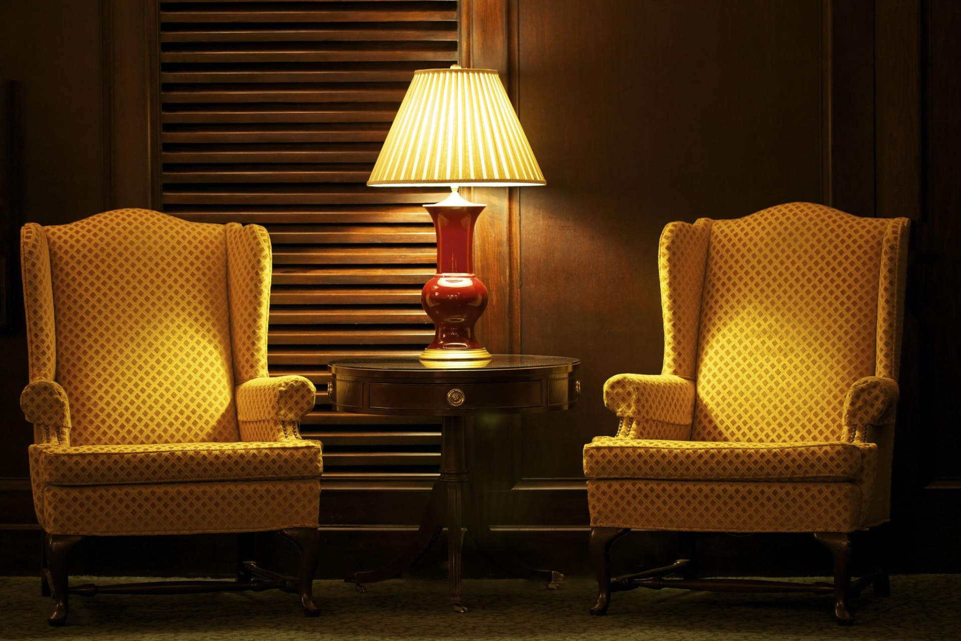 Two armchairs facing one another in a quiet, softly lit room.
