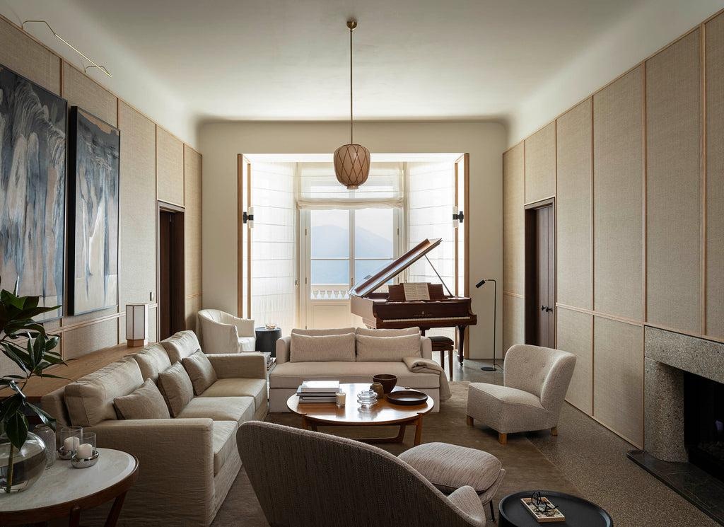 A calm lakeside drawing room with a grand piano framed by open doors.