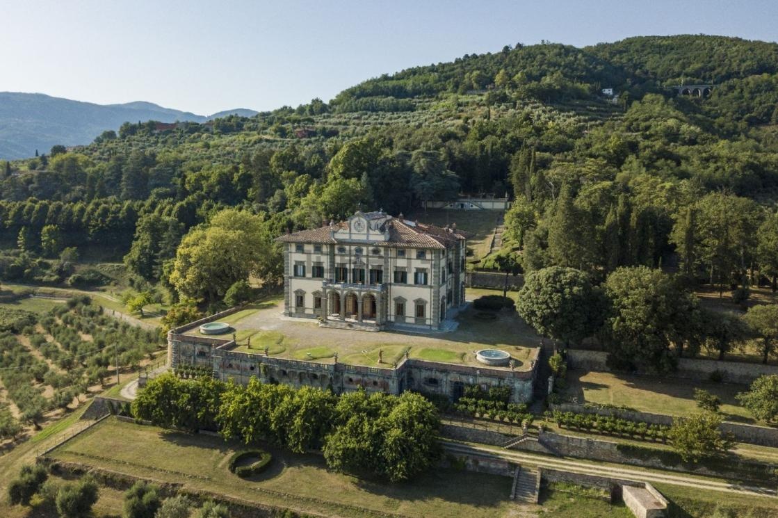 An aerial view of a historic Italian villa within its estate and olive groves.