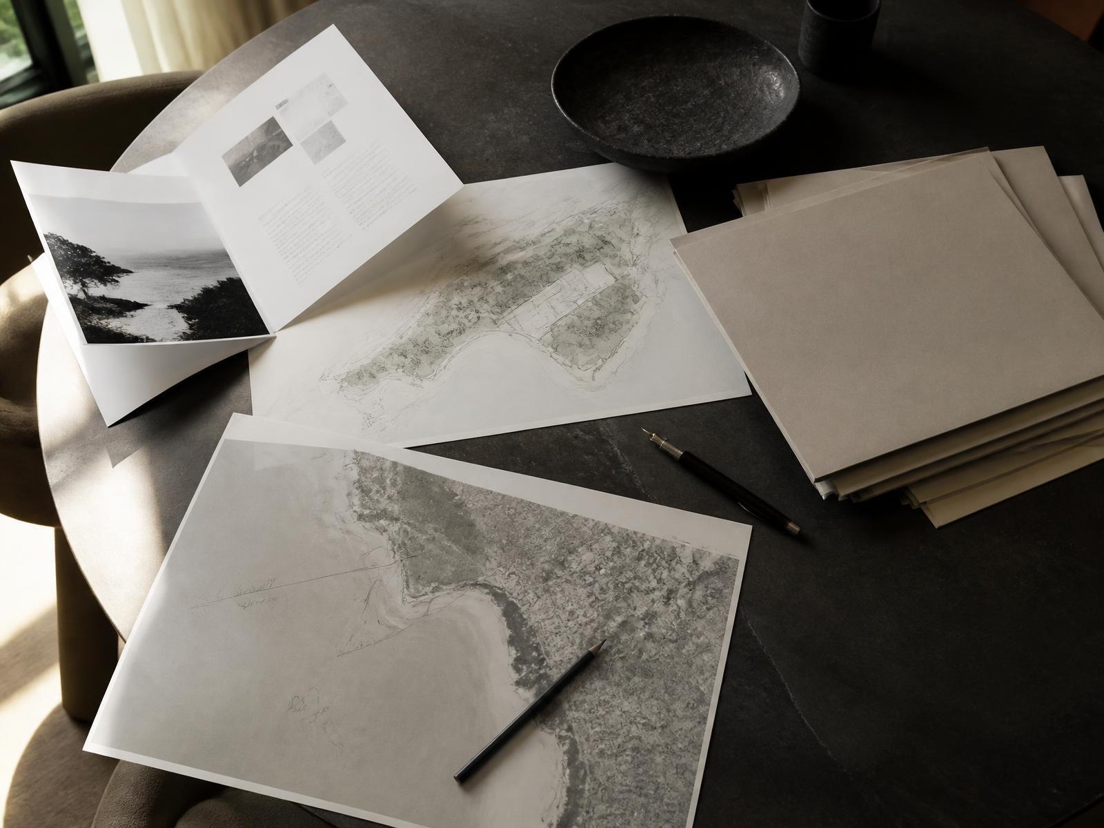 An acquisition brief, annotated site plans and shortlisted property dossiers laid out on a private advisory table.